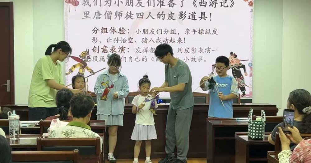 图9 赵梓渟、葛泽宇同学协助小朋友体验皮影道具
